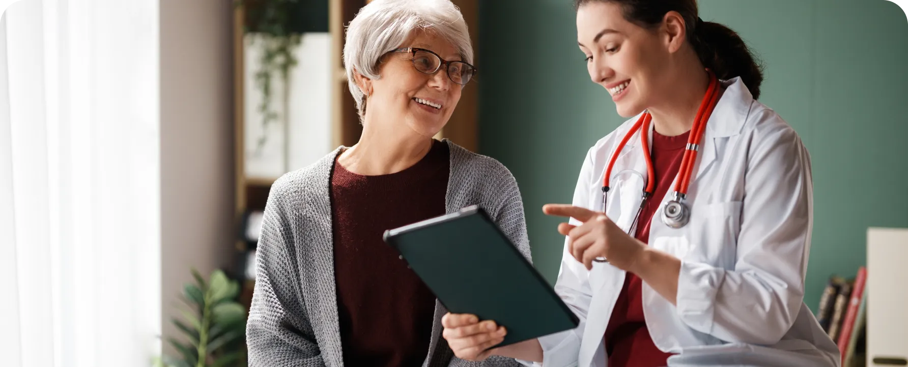 A provider holding a clipboard talks to a patient about insurance options.